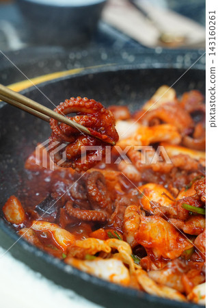 Picking Up Spicy Stir-Fried Webfoot Octopus with Chopsticks, Authentic Korean Seafood Dish (Jjukkumi-bokkeum) Picking Up Spicy Stir-Fried Webfoot Octopus with Chopsticks, Authentic Korean Seafood Dish (Jjukkumi-bokkeum) 143160261