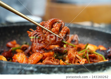 Picking Up Spicy Stir-Fried Webfoot Octopus with Chopsticks, Authentic Korean Seafood Dish (Jjukkumi-bokkeum) Picking Up Spicy Stir-Fried Webfoot Octopus with Chopsticks, Authentic Korean Seafood Dish (Jjukkumi-bokkeum) 143160262