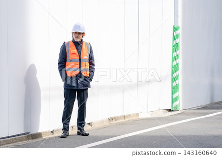 在建築工地工作的幾位老年人正在指揮交通。 在建築工地工作的幾位老年人正在指揮交通。 143160640