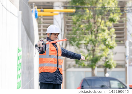 在建築工地工作的幾位老年人正在指揮交通。 在建築工地工作的幾位老年人正在指揮交通。 143160645