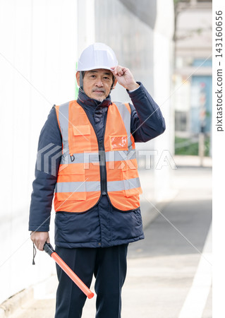 在建築工地工作的幾位老年人正在指揮交通。 在建築工地工作的幾位老年人正在指揮交通。 143160656