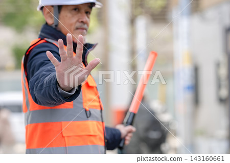 在建築工地工作的幾位老年人正在指揮交通。 在建築工地工作的幾位老年人正在指揮交通。 143160661