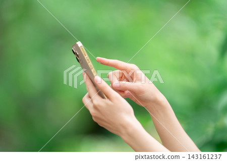 A woman who operates a smartphone A woman who operates a smartphone 143161237