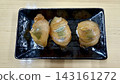 光澤誘人的醃製鯛魚刺身壽司擺放在黑色盤子上。 143161272