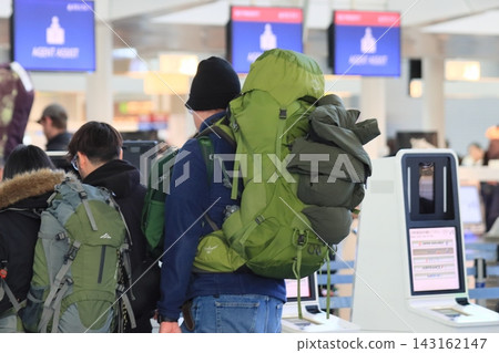 Passengers with large backpacks checking in for boarding. Passengers with large backpacks checking in for boarding. 143162147