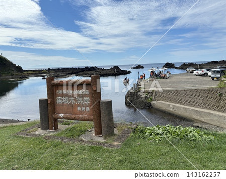 A view of the rocky reefs and tub boats of Shukunegi Beach under a blue sky and cirrocumulus clouds. A view of the rocky reefs and tub boats of Shukunegi Beach under a blue sky and cirrocumulus clouds. 143162257