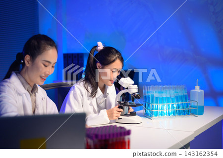 Two Female Scientists Working in Modern Laboratory with Microscope and Test Tubes Two Female Scientists Working in Modern Laboratory with Microscope and Test Tubes 143162354