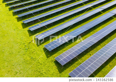 Solar panels installed in a large green field generating clean energy. Aerial view. Solar panels installed in a large green field generating clean energy. Aerial view. 143162586