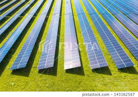 Solar panels installed in a large green field generating clean energy. Aerial view. Solar panels installed in a large green field generating clean energy. Aerial view. 143162587