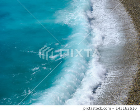 Big storm waves crashing on a pebble beach with azure water. Big storm waves crashing on a pebble beach with azure water. 143162610