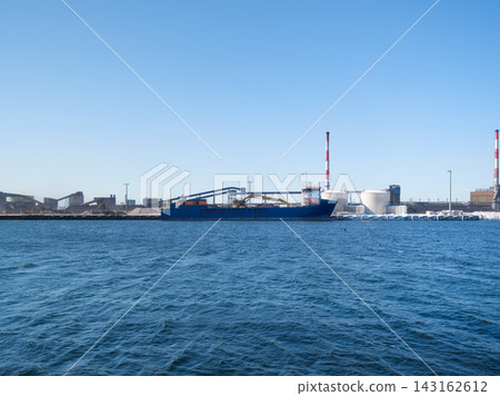 Cargo ship loading steel products at a port near a heavy industrial metallurgical plant. Cargo ship loading steel products at a port near a heavy industrial metallurgical plant. 143162612