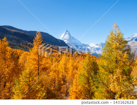 Matterhorn mountain peak rising above a colorful autumn forest in Zermatt, Switzerland. Matterhorn mountain peak rising above a colorful autumn forest in Zermatt, Switzerland. 143162628