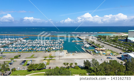 一艘遊艇停泊在沖繩縣宜野灣市益城港,以及美麗清澈的藍色海景。 一艘遊艇停泊在沖繩縣宜野灣市益城港,以及美麗清澈的藍色海景。 143162783