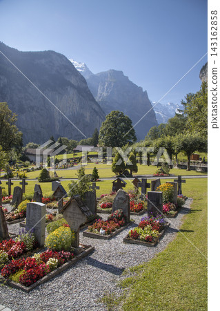 Lauterbrunnen valley cemetery with mountains and blooming flowers Lauterbrunnen valley cemetery with mountains and blooming flowers 143162858