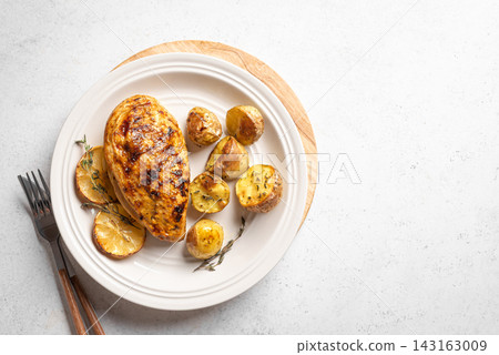 Oven roasted lemon garlic chicken and potatoes on plate Oven roasted lemon garlic chicken and potatoes on plate 143163009
