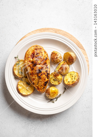 Oven roasted lemon garlic chicken and potatoes on plate Oven roasted lemon garlic chicken and potatoes on plate 143163010