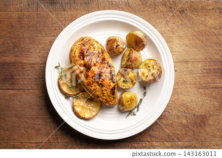 Oven roasted lemon garlic chicken and potatoes on plate Oven roasted lemon garlic chicken and potatoes on plate 143163011