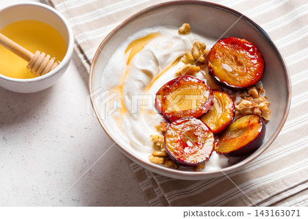 Roasted plums with yogurt, honey and nuts Roasted plums with yogurt, honey and nuts 143163071