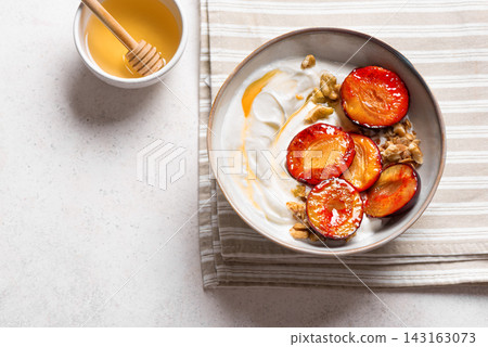 Roasted plums with yogurt, honey and nuts Roasted plums with yogurt, honey and nuts 143163073