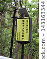 A sign and a surveillance camera that read "No littering - surveillance cameras in operation." 143163344