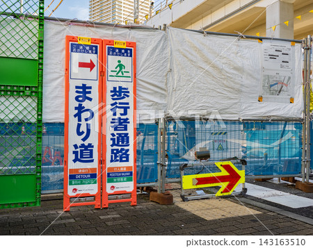 Detour guidance for pedestrian walkways due to road construction; temporary signs indicating alternative routes. 143163510