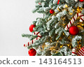 Christmas tree with frosted snowy branches decorated with red and white ornaments with lights 143164513