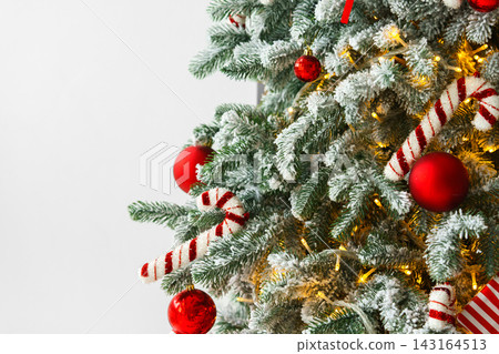 Christmas tree with frosted snowy branches decorated with red and white ornaments with lights Christmas tree with frosted snowy branches decorated with red and white ornaments with lights 143164513
