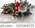 Two elegant crystal tall glasses with festive evergreen decor for Christmas holiday dinner 143164515