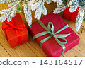 Red wrapped gift boxes, presents under festive Christmas tree with lights and holiday decorations 143164517