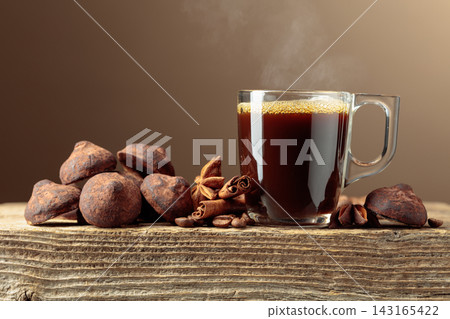 Chocolate truffles and black coffee on a wooden table. Chocolate truffles and black coffee on a wooden table. 143165422