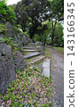 A walking path featuring impressive rock formations and stone steps nestled among the trees of Hibiya Park. 143166345