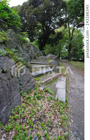 一條步行小徑，兩側是壯觀的岩石構造和石階，掩映在日比谷公園的樹木之中。 143166345