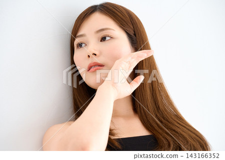 一名女子手托腮,側過臉去。 一名女子手托腮,側過臉去。 143166352