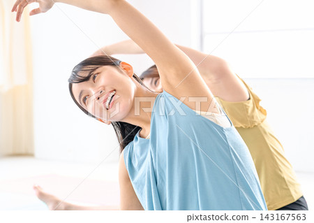女人們微笑著伸展著身體。 女人們微笑著伸展著身體。 143167563
