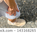 An elderly woman's hand holding her thigh - from above 143168265