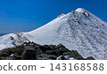 A view of the snow-covered main peak of Mt. Iwaki from the summit of Mt. Iwaki in April, showing the ringing rock and the snow-covered main peak of Mt. Iwaki. 143168588