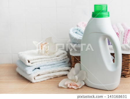 Laundry detergent bottle with fresh clean towels and orchids 143168631