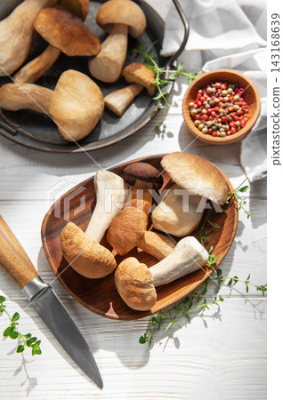 Porcini mushrooms with fresh herbs and spices on wooden table Porcini mushrooms with fresh herbs and spices on wooden table 143168639