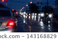 Abstract of cars wait in a traffic queue on a wet urban street at night during heavy rain. With glowing red brake lights and shimmering reflections. 143168829