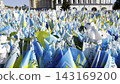 Many small blue-yellow flags with names of the dead war against russia. Memorial of the fallen soldiers, children, women in the capital of Ukraine. Concept of tragedy and misfortune. Close up 143169200