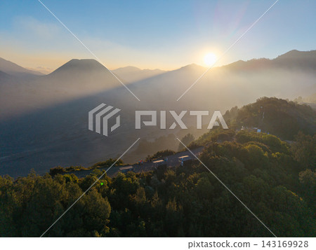 Sun glows through misty mountain peaks Sun glows through misty mountain peaks 143169928
