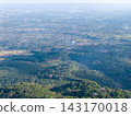 Vast green valley stretches beneath hazy sky 143170018