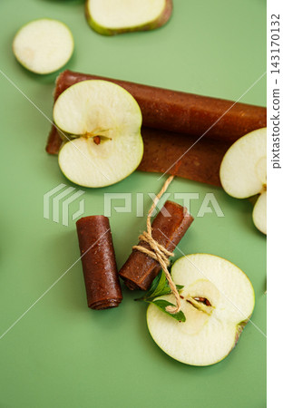 Dried apple fruit snack with mint leaves on green background Dried apple fruit snack with mint leaves on green background 143170132