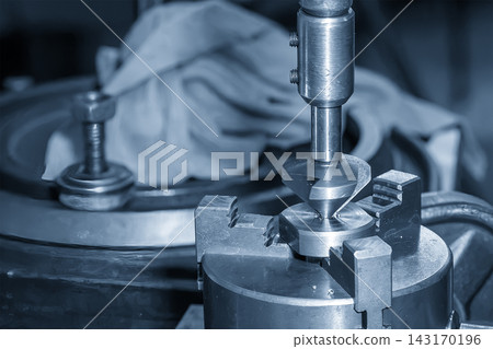 Hole deburring process using a chamfer tool on a milling machine in a blue tone scene Hole deburring process using a chamfer tool on a milling machine in a blue tone scene 143170196