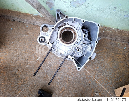 High angle shot of metal motor part. Cleaned engine block section. Cast aluminum mechanical housing with studs for motorcycle repair projects. High angle shot of metal motor part. Cleaned engine block section. Cast aluminum mechanical housing with studs for motorcycle repair projects. 143170475