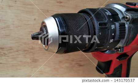 Close-Up of a Cordless Electric Drill Chuck and Torque Selector on Wooden Background Close-Up of a Cordless Electric Drill Chuck and Torque Selector on Wooden Background 143170537