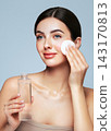 Young woman cleansing face with cosmetic milk 143170813