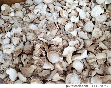 Sliced dried white ginger root pieces heap for traditional herbal tea medicine. Sliced dried white ginger root pieces heap for traditional herbal tea medicine. 143170947
