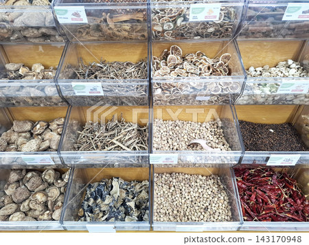 Assorted dried herbs and spices displayed in transparent acrylic storage bins. Assorted dried herbs and spices displayed in transparent acrylic storage bins. 143170948