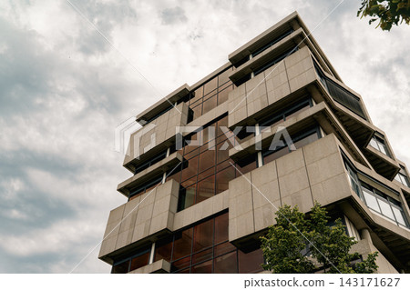 Modernist Concrete Office Building Under Cloudy Sky 143171627
